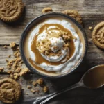 Creamy Cookie Butter Latte topped with whipped cream, cookie butter drizzle, and cookie crumbs on a rustic wooden table.